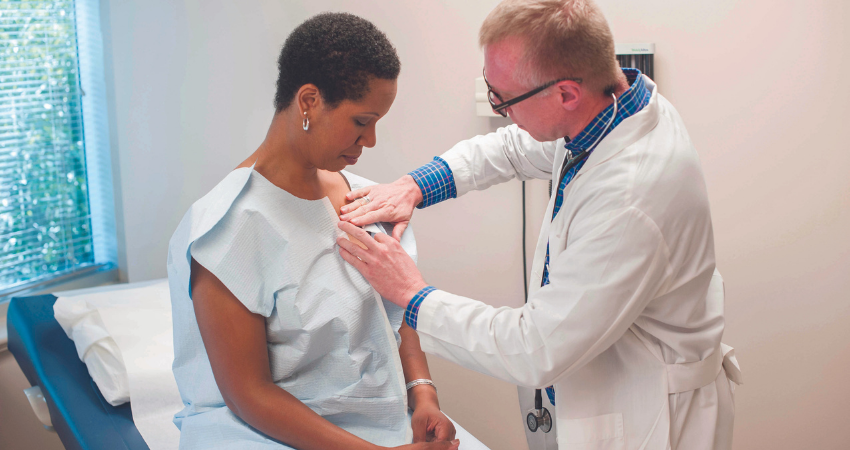 White male doctor with Black female patient